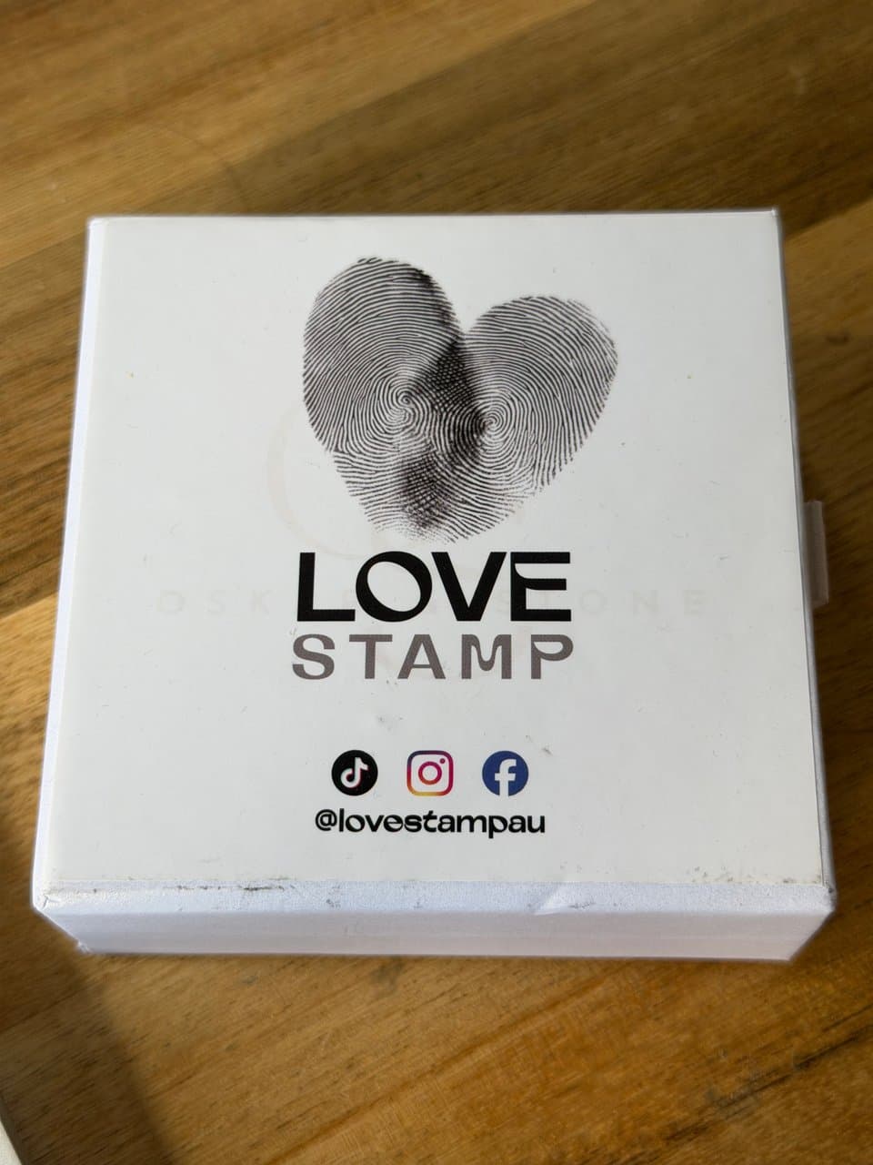 The white LoveStamp presentation box with our fingerprint heart and LoveStamp logo